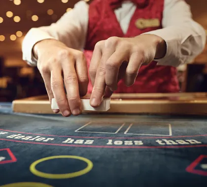 A casino dealer's hands handling a deck of playing cards